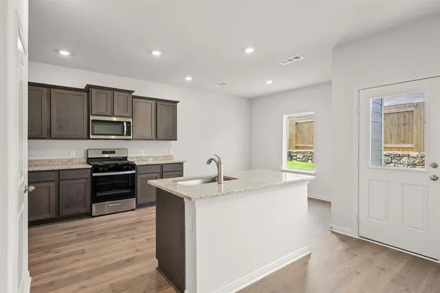 a kitchen with a sink stove and refrigerator