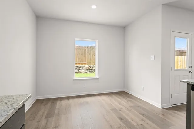 an empty room with wooden floor and a window