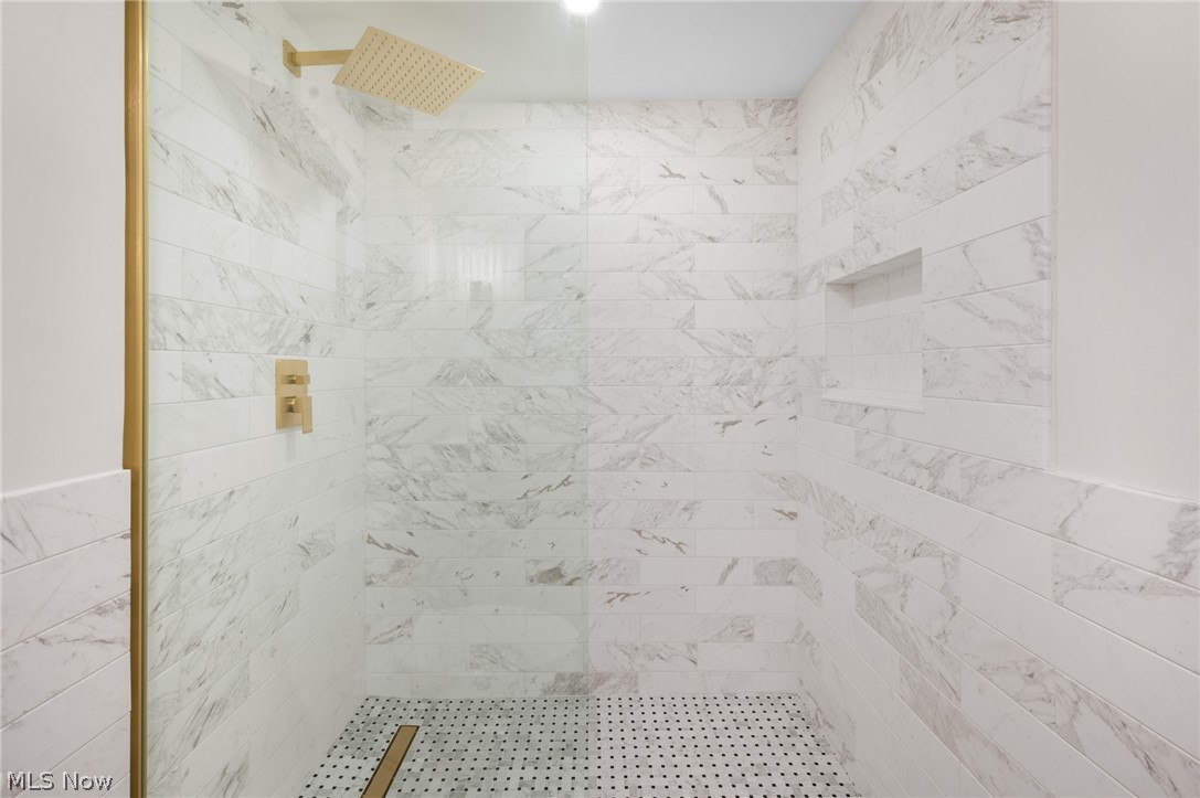 22625 Rye Road Shaker Heights, OH 44122 - Photo 22 of 38 Walk-in shower featuring gold-finish fixtures, a rainfall showerhead, and a recessed niche