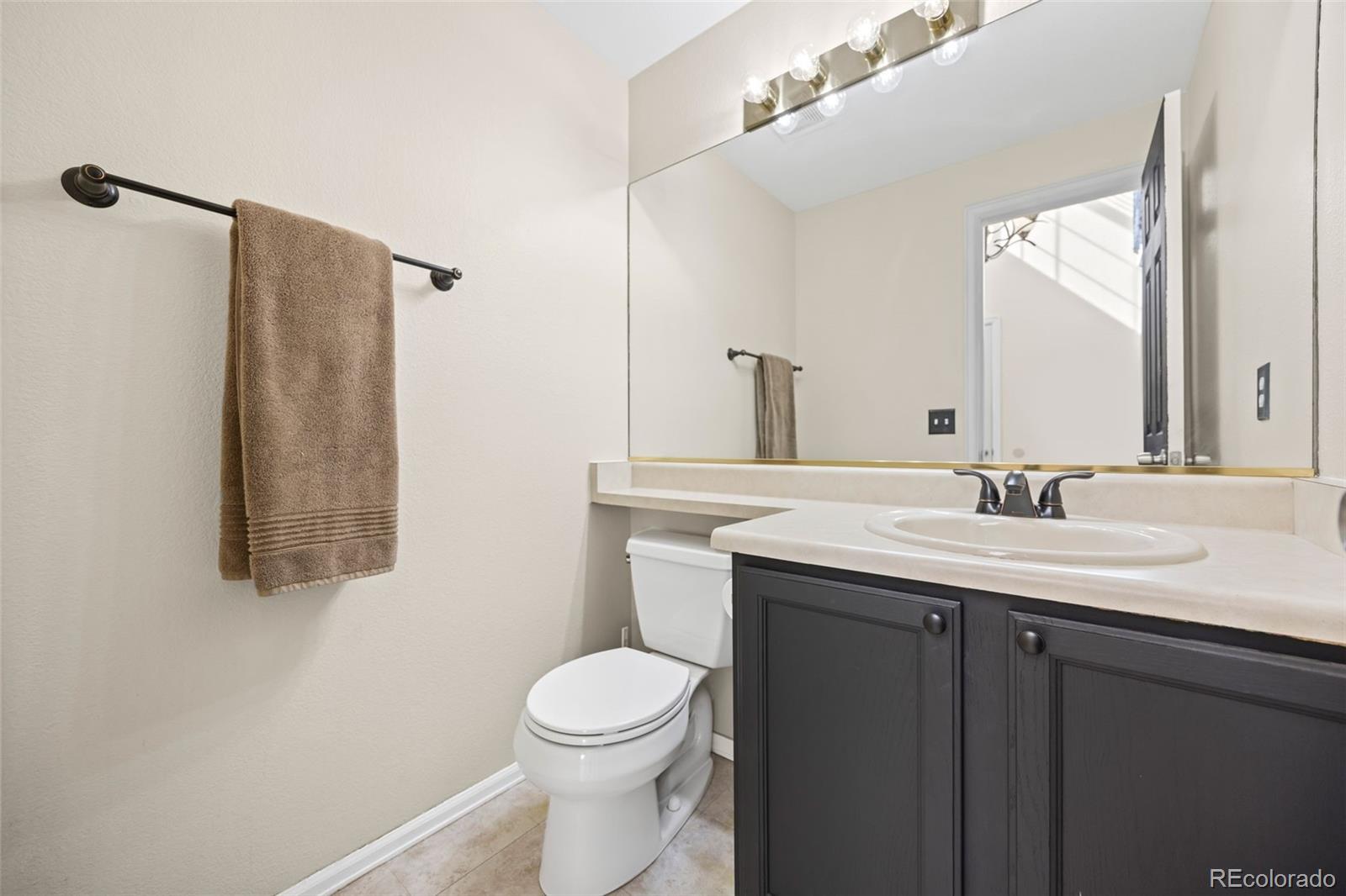 11100 Callaway Court Parker, CO 80138 - Photo 12 of 39 a bathroom with a granite countertop sink toilet and mirror