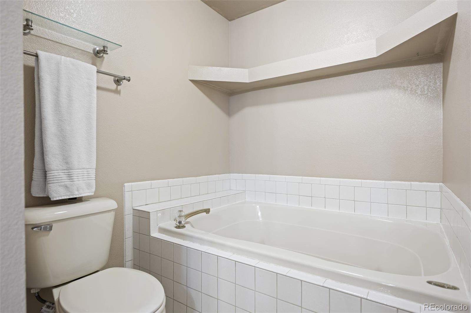 11100 Callaway Court Parker, CO 80138 - Photo 16 of 39 a bathroom with a toilet and a bathtub