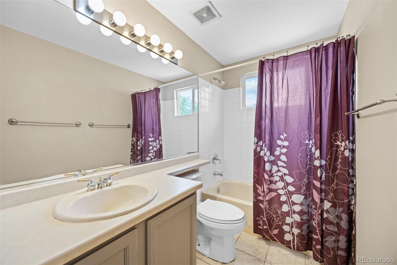 11100 Callaway Court Parker, CO 80138 - Photo 18 of 39 a bathroom with a sink a toilet and shower curtain