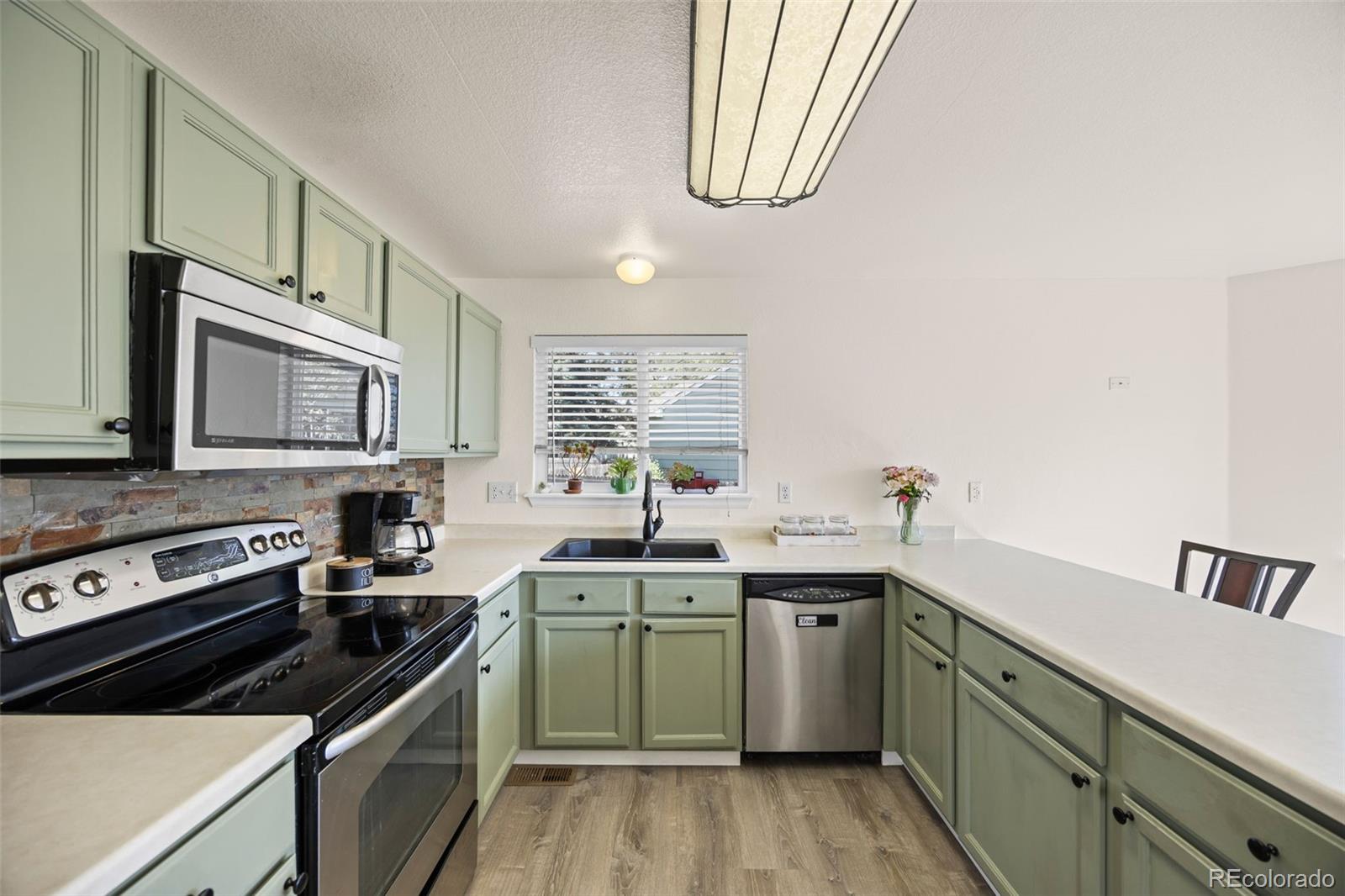 11100 Callaway Court Parker, CO 80138 - Photo 9 of 39 a kitchen with a sink stove and microwave