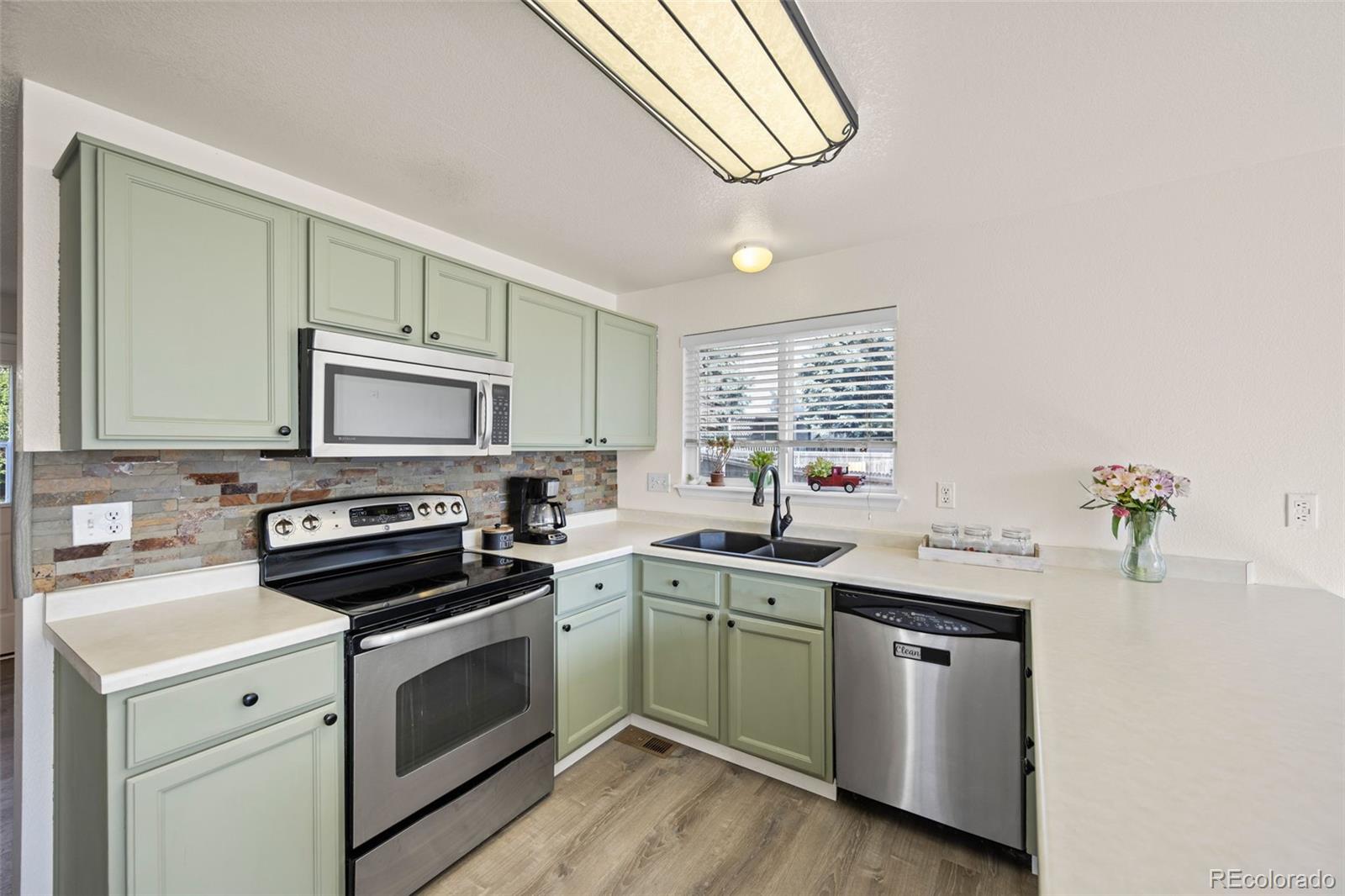 11100 Callaway Court Parker, CO 80138 - Photo 10 of 39 a kitchen with a sink cabinets and appliances