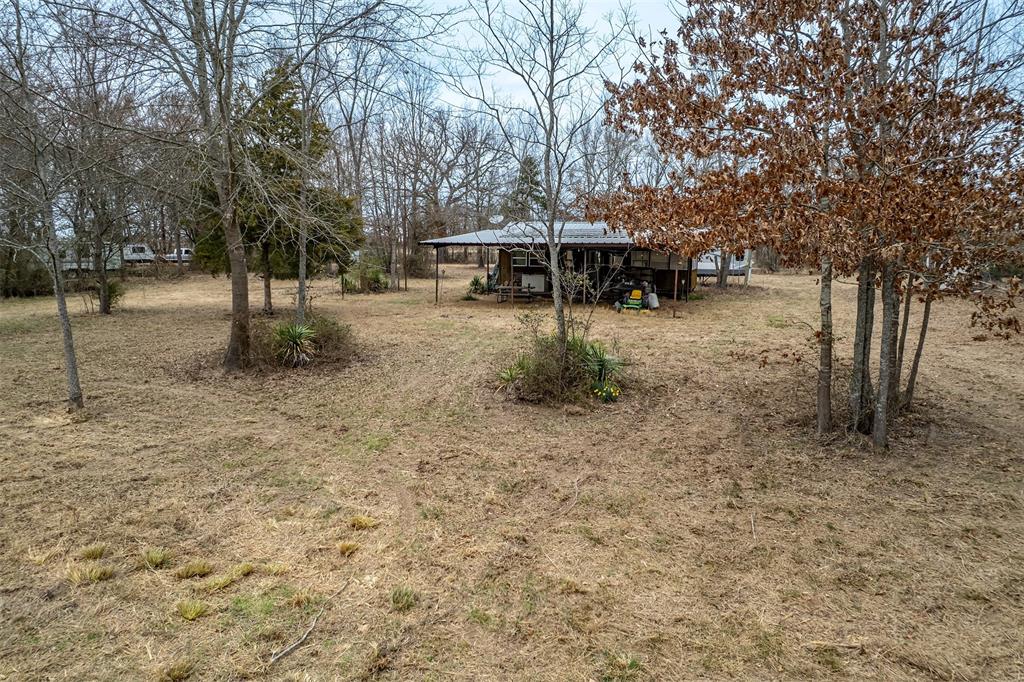 139 Northwest County Road, Unit 1061 Talco, TX 75487 - Photo 25 of 39 a backyard of a house with table and chairs
