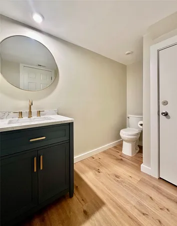 a bathroom with a sink vanity mirror and toilet