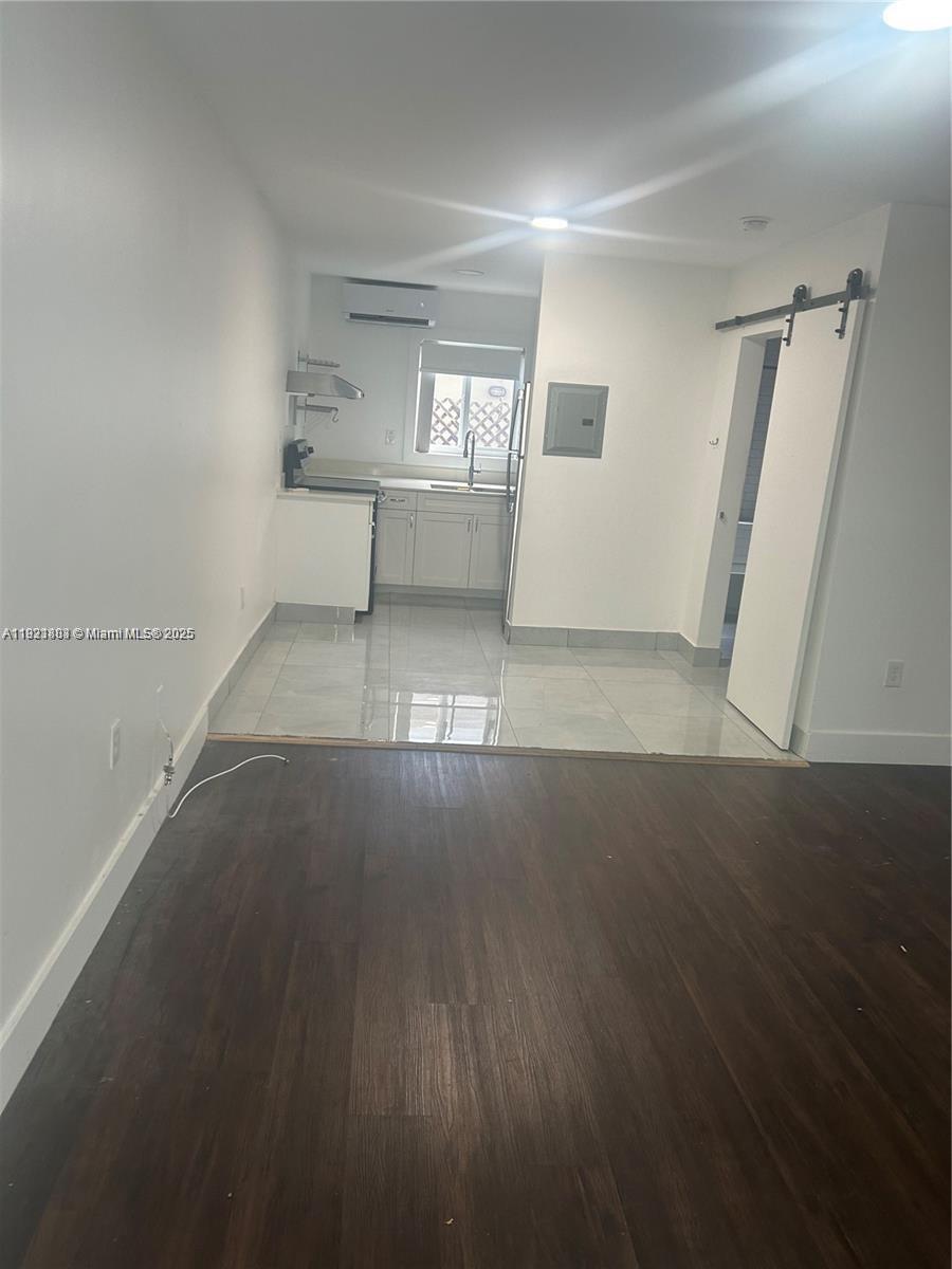 8260 Byron Avenue, Unit 13 Miami Beach, FL 33141 - Photo 5 of 5 an empty room with wooden floor and windows
