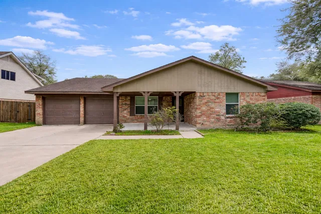 a front view of a house with a garden and yard