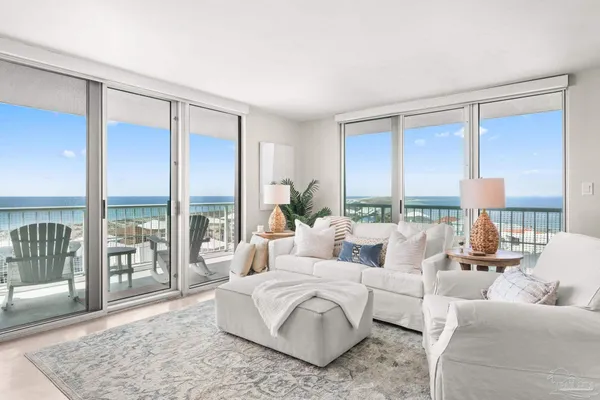 a living room with furniture a flat screen tv and a floor to ceiling window
