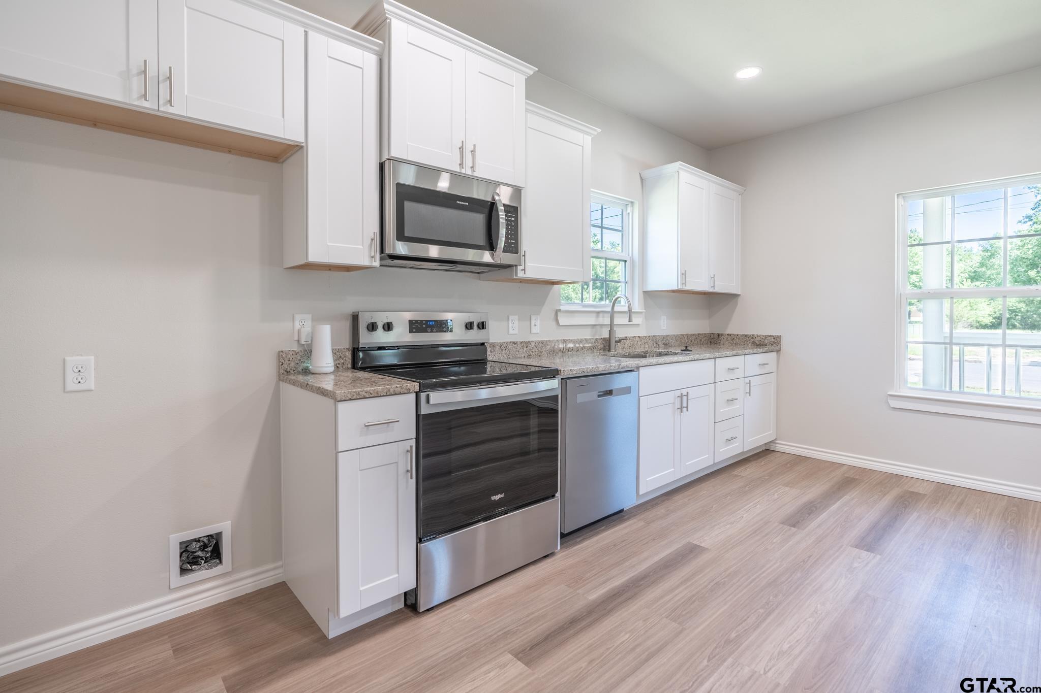 233 Harrison Street Longview, TX 75601 - Photo 14 of 44 a kitchen with stainless steel appliances granite countertop a stove a sink and a microwave
