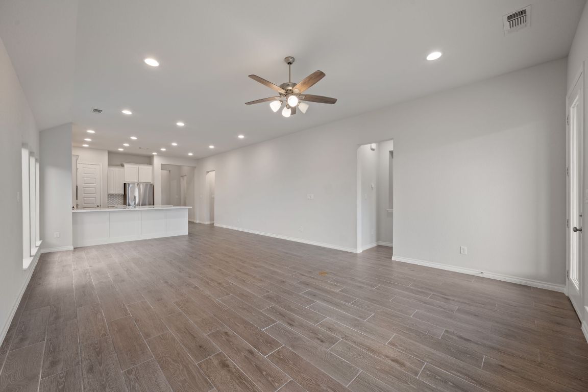 1037 Thunderhead Trail Georgetown, TX 78628 - Photo 11 of 33 a view of an empty room with wooden floor and a ceiling fan