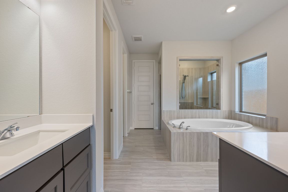 1037 Thunderhead Trail Georgetown, TX 78628 - Photo 14 of 33 a bathroom with a sink a mirror and a bathtub
