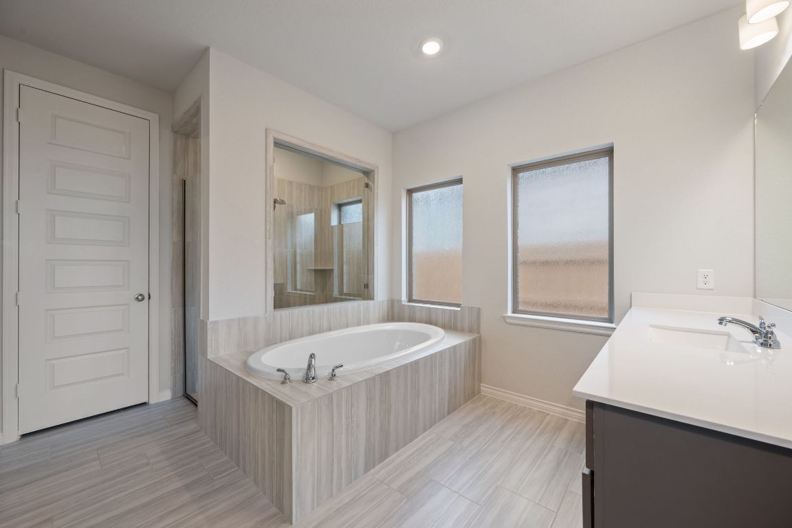 1037 Thunderhead Trail Georgetown, TX 78628 - Photo 15 of 33 a bathroom with a tub sink and mirror