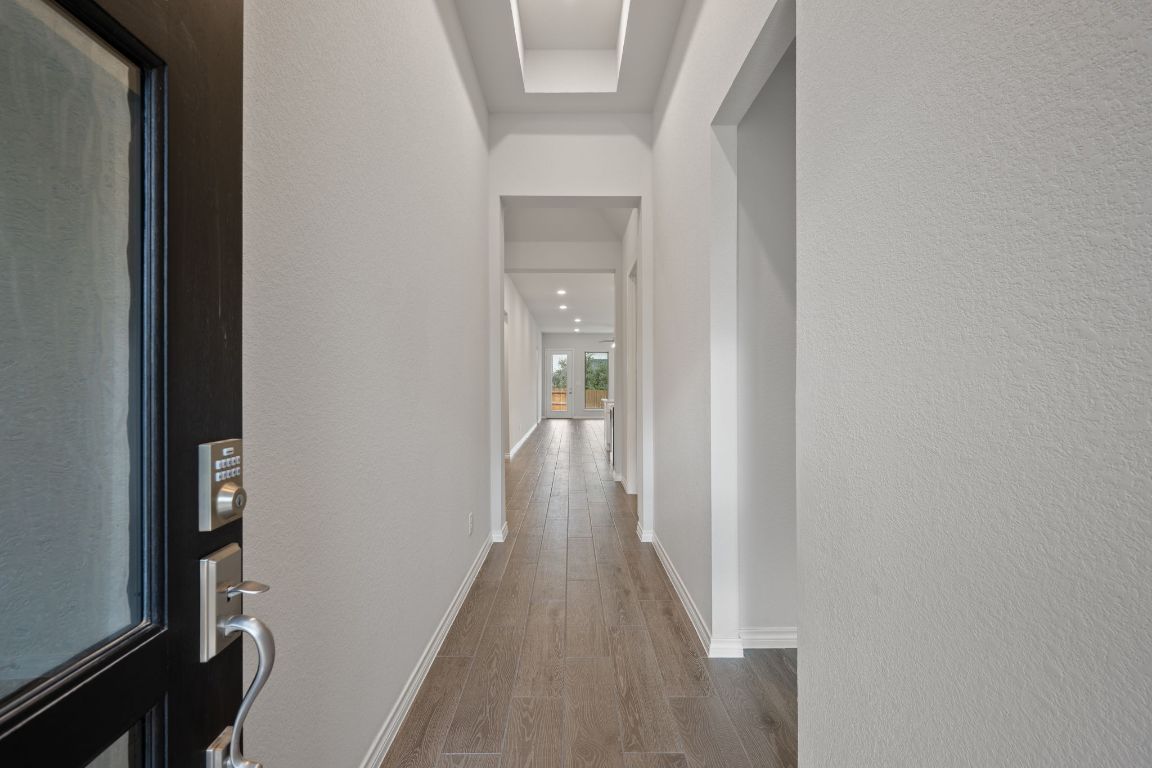 1037 Thunderhead Trail Georgetown, TX 78628 - Photo 4 of 33 a view of a hallway with wooden floor and a bathroom