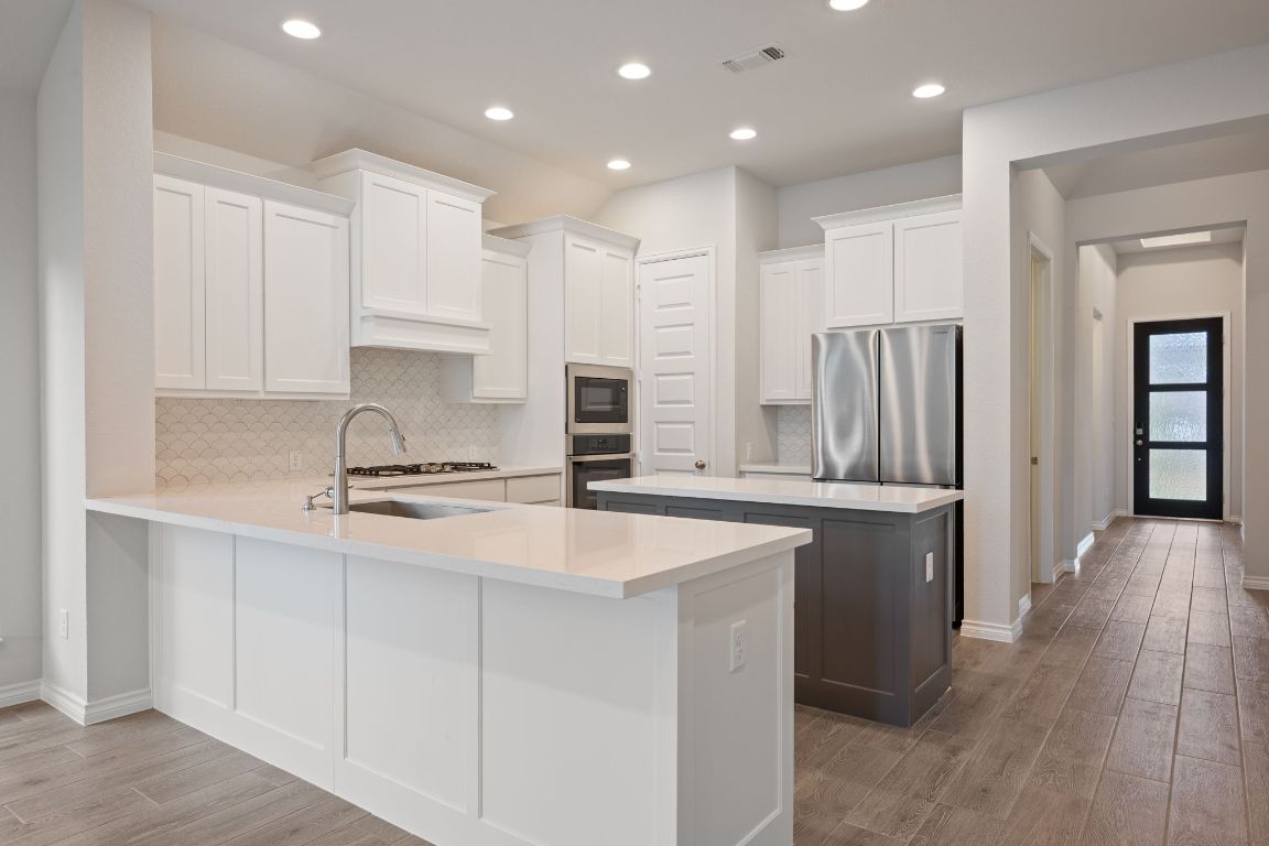 1037 Thunderhead Trail Georgetown, TX 78628 - Photo 6 of 33 a kitchen with stainless steel appliances granite countertop a refrigerator a sink and a stove