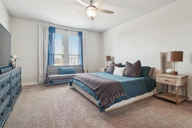 a spacious bedroom with a bed and a chandelier