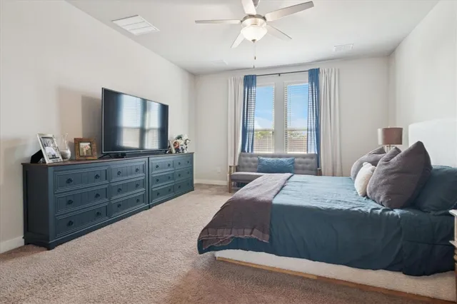 a bedroom with a large bed and a flat tv screen on dresser