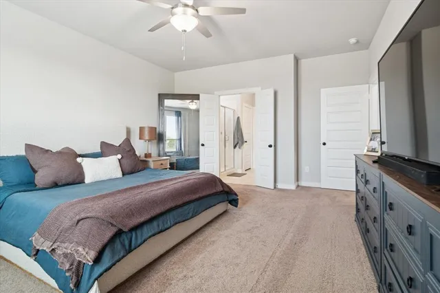 a spacious bedroom with a large bed and a chandelier