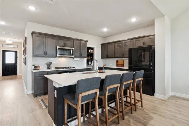 a kitchen with kitchen island granite countertop wooden cabinets and stainless steel appliances