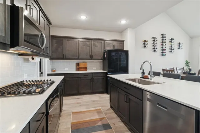 a kitchen with stainless steel appliances a sink stove and refrigerator