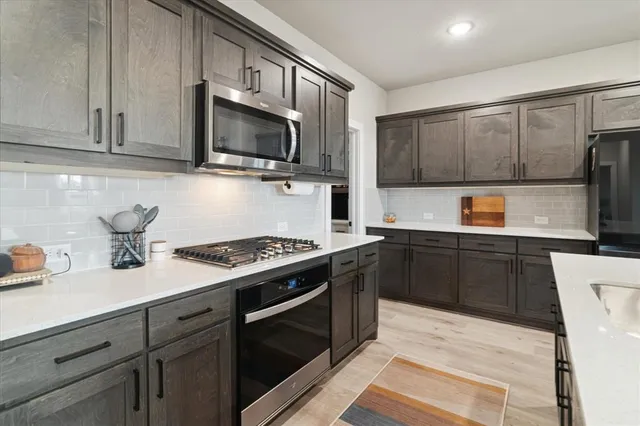 a kitchen with stainless steel appliances granite countertop a sink stove and microwave