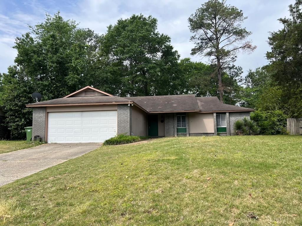 a front view of a house with yard and trees