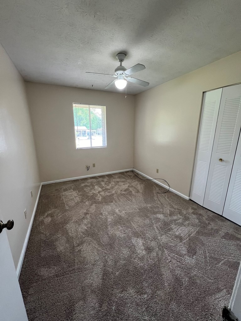 6323 Old Post Court Columbus, GA 31909 - Photo 6 of 13 an empty room with a ceiling fan and window