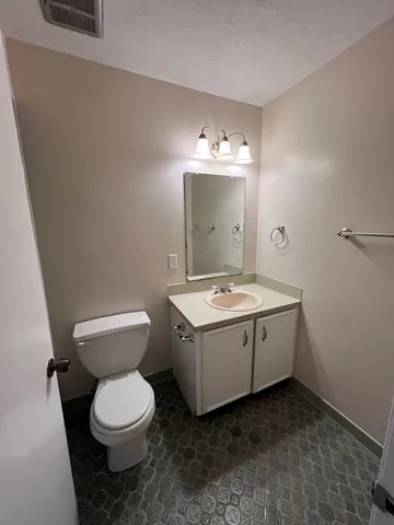 a bathroom with a sink and mirror with toilet