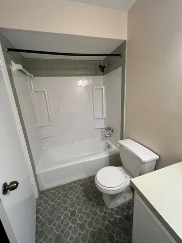 a bathroom with a toilet and a shower