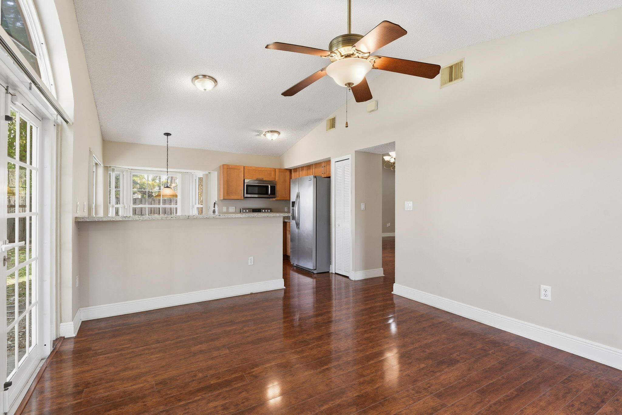 7350 Southwest 161st Place Miami, FL 33193 - Photo 6 of 31 a view of a kitchen with a refrigerator a ceiling fan and wooden floor