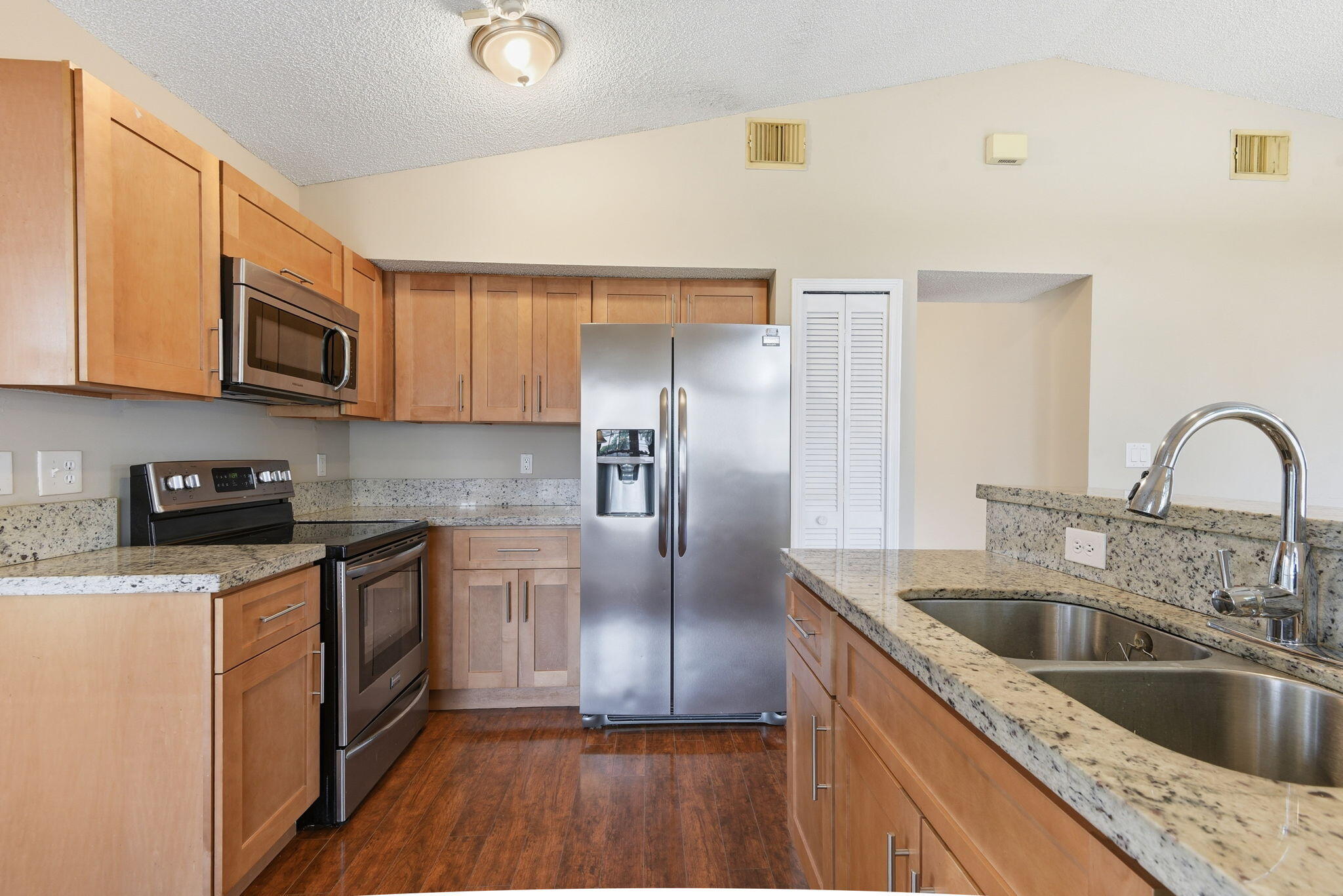 7350 Southwest 161st Place Miami, FL 33193 - Photo 7 of 31 a kitchen with stainless steel appliances granite countertop a sink a stove and a refrigerator