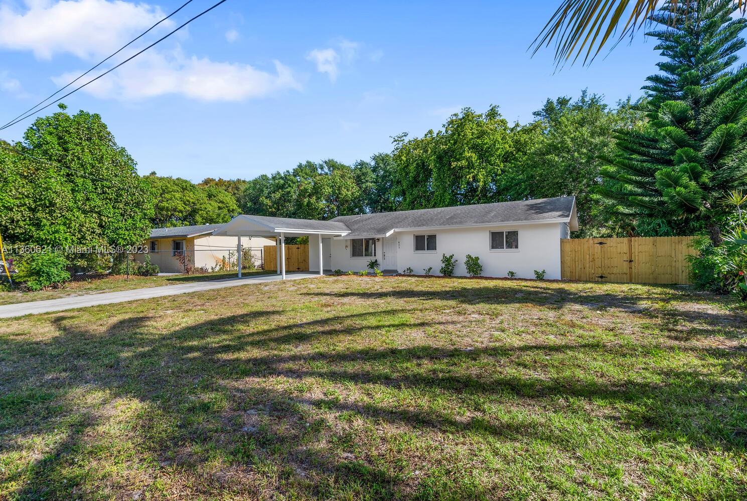 a front view of house with yard and trees in the background