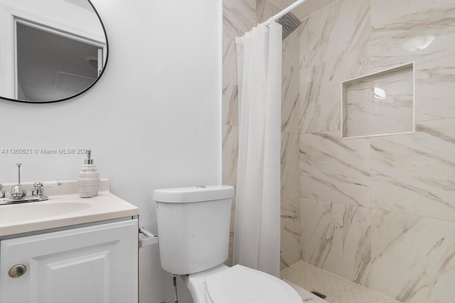 611 Davis Road Delray Beach, FL 33445 - Photo 13 of 22 a bathroom with a sink toilet and mirror