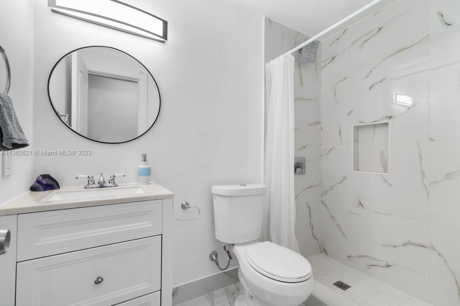 611 Davis Road Delray Beach, FL 33445 - Photo 15 of 22 a bathroom with a toilet sink vanity granite and a mirror