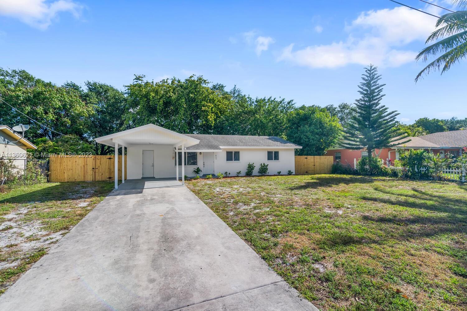 611 Davis Road Delray Beach, FL 33445 - Photo 2 of 22 a front view of house with yard and trees in the background