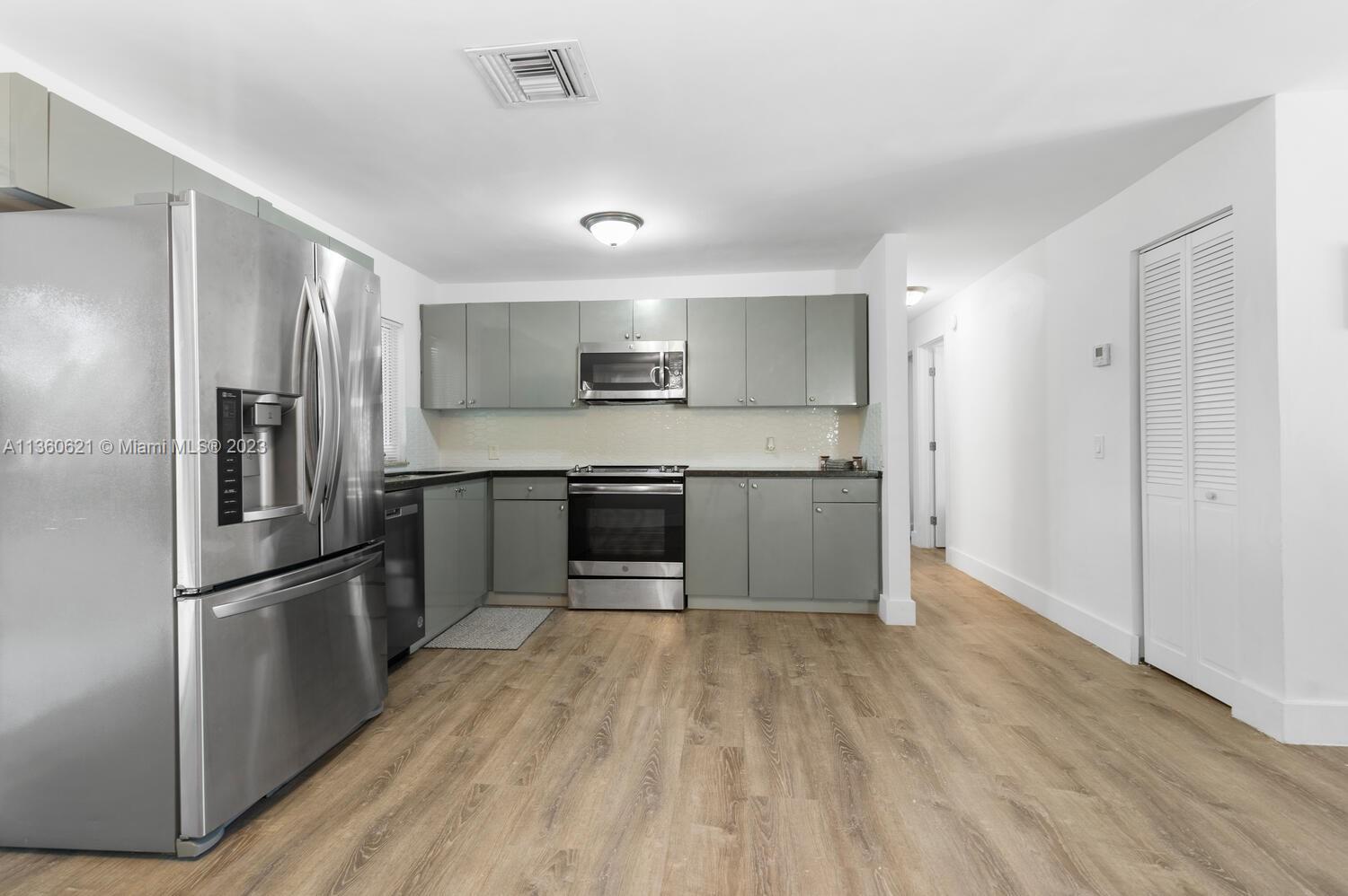 611 Davis Road Delray Beach, FL 33445 - Photo 5 of 22 a kitchen with wooden floors and stainless steel appliances