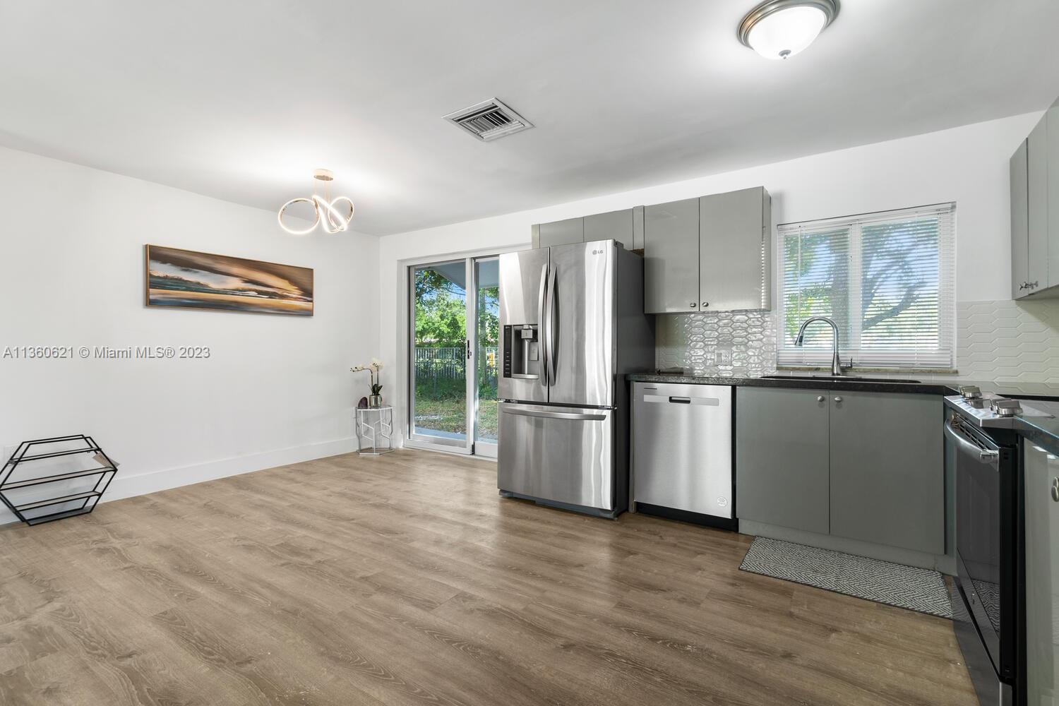 611 Davis Road Delray Beach, FL 33445 - Photo 6 of 22 a kitchen with stainless steel appliances granite countertop a refrigerator and a stove top oven