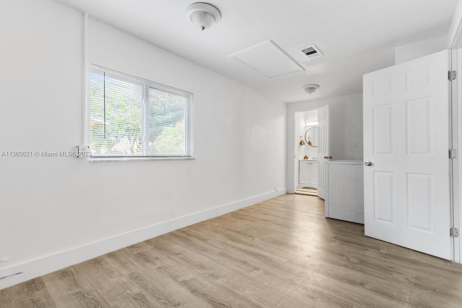 611 Davis Road Delray Beach, FL 33445 - Photo 7 of 22 an empty room with wooden floor and windows