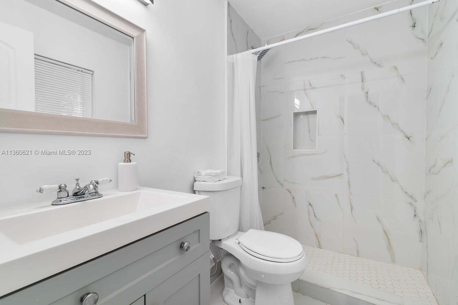 611 Davis Road Delray Beach, FL 33445 - Photo 10 of 22 a bathroom with a sink toilet and shower
