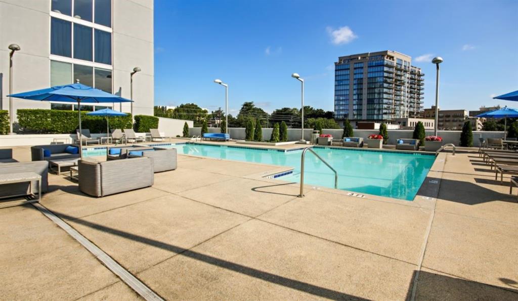 2171 Peachtree Road, Unit 1403 Atlanta, GA 30309 - Photo 13 of 25 a view of a patio with a table and chairs under an umbrella with large trees