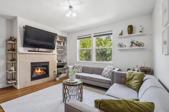 a living room with furniture a flat screen tv and a fireplace