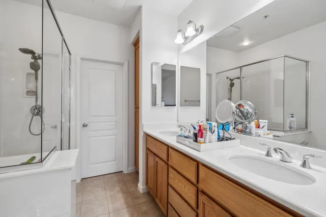 a bathroom with a double vanity sink mirror and shower