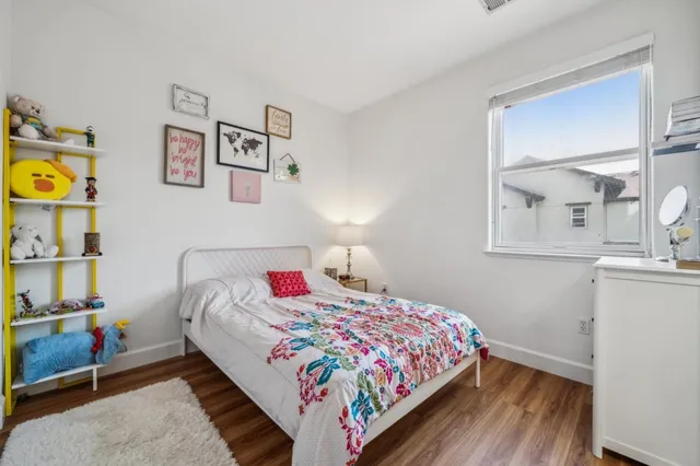 a bedroom with a bed and painting on the wall