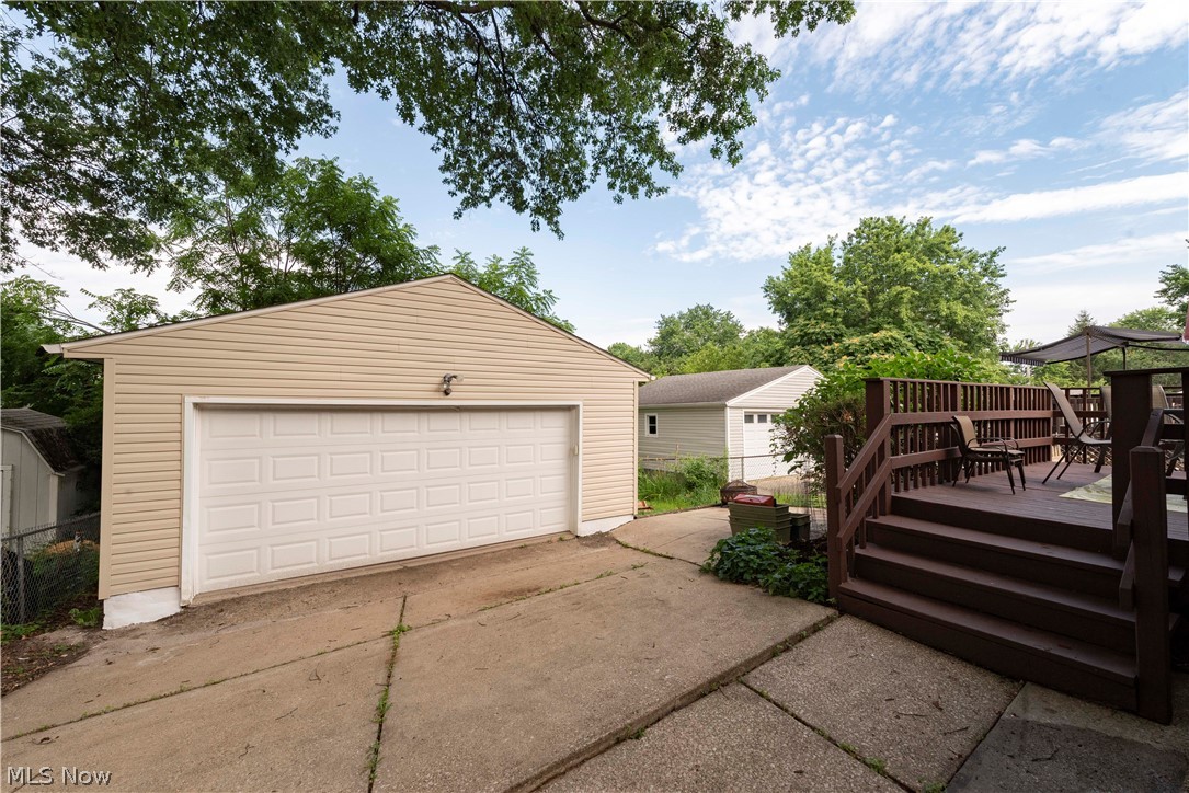 400 Baldwin Road Akron, OH 44312 - Photo 2 of 43 Expansive rear yard featuring a detached 2 car garage with a white panel door, concrete driveway, and a multi-level wooden deck