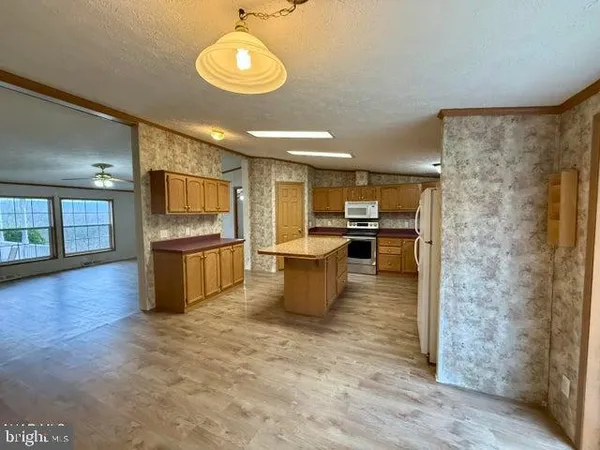 a kitchen with stainless steel appliances kitchen island wooden cabinets and granite counter tops