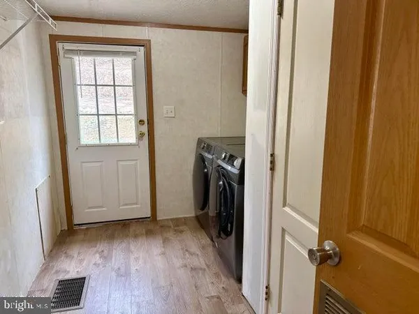 a view of an empty room with a fireplace and a window
