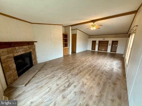 a view of a livingroom with wooden floor and a fireplace