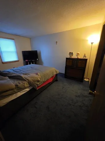 a spacious bedroom with a bed and a window