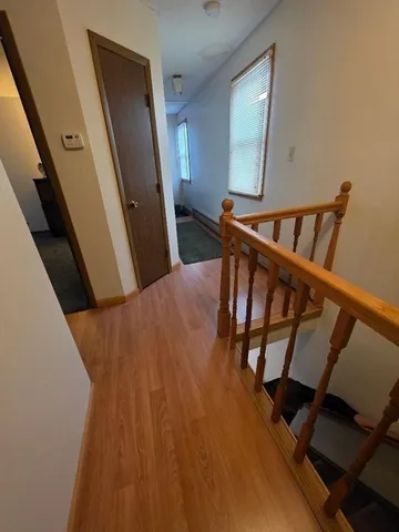 a view of a hallway with wooden floor and stairs