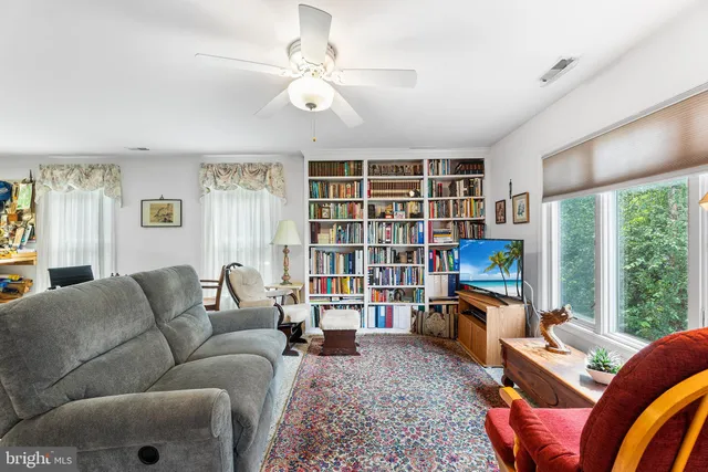 a spacious bedroom with a bed dresser and a large window